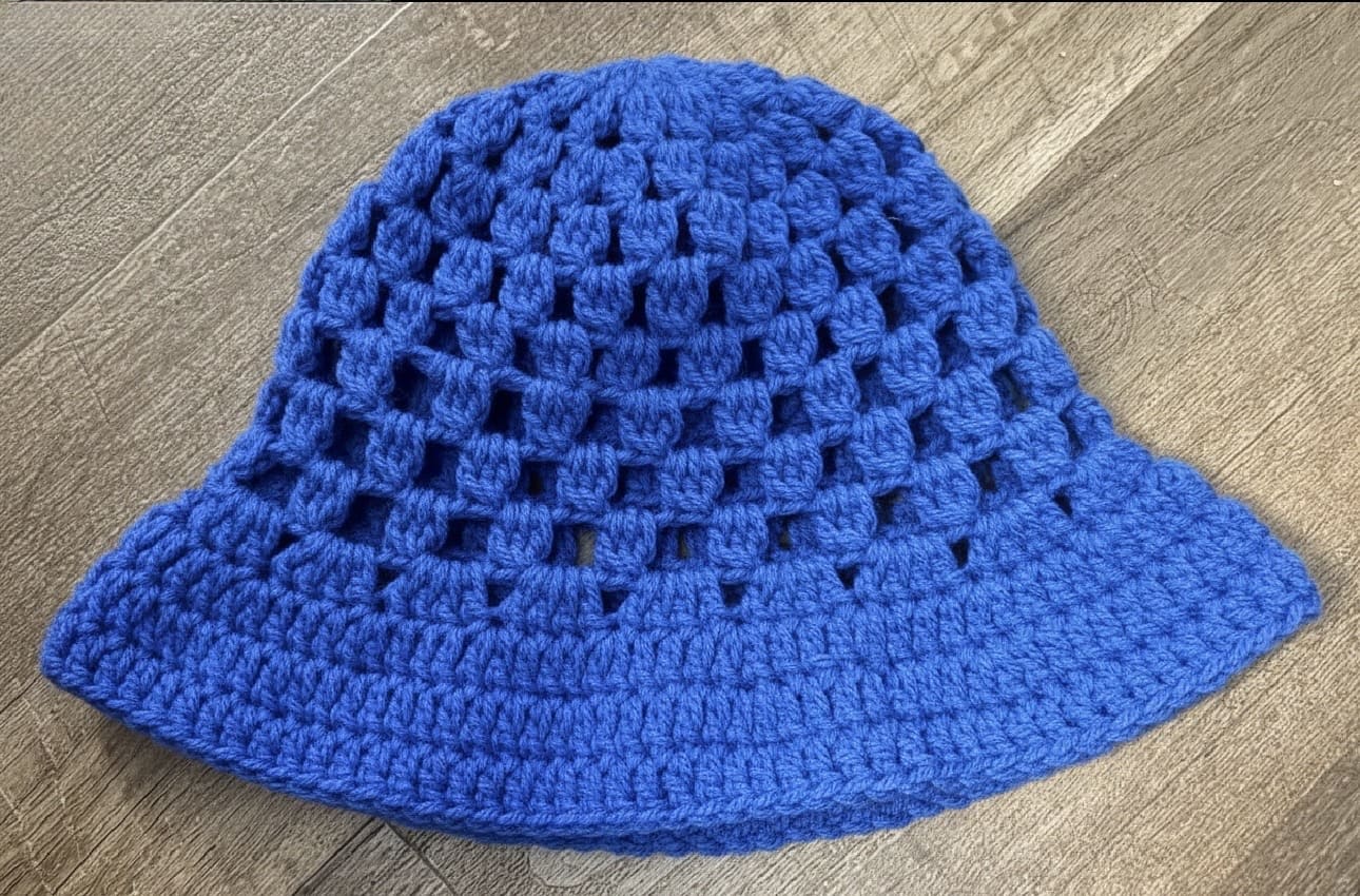 Blue crochet hat on a wooden surface